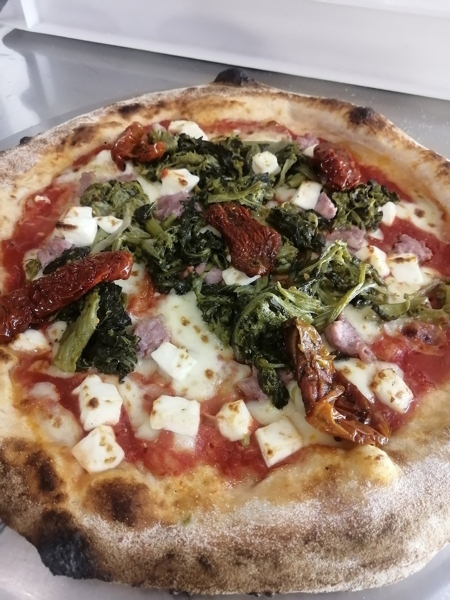 Pizza napoletana con salsiccia fresca nostrana, friarielli saltati, pomodori secchi e cubetti di formaggio